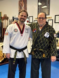 Peter D. Bethke in a black belt, with Grandmaster Thomas Henzey